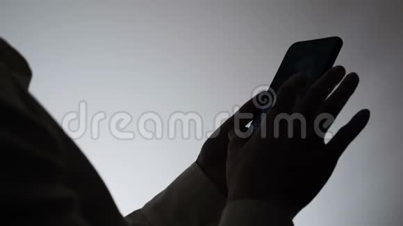 白色背景的女人的剪影一个女人在电话里写信息女人用互联网视频的预览图