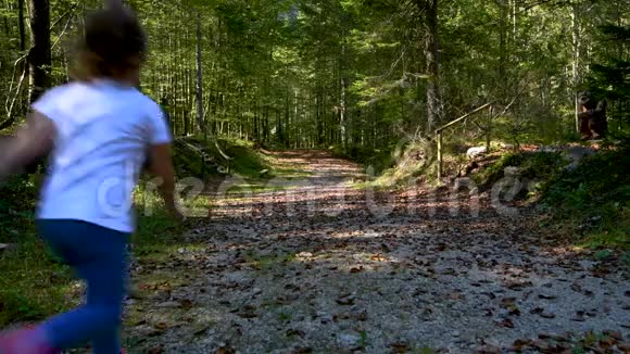 女孩在母亲身后的森林里奔跑视频的预览图