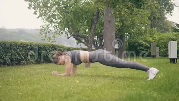健身女子夏季公园草地木板运动视频的预览图