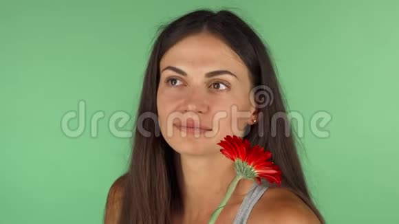 美丽的女人微笑着带着一朵花梦幻般地望着远方视频的预览图