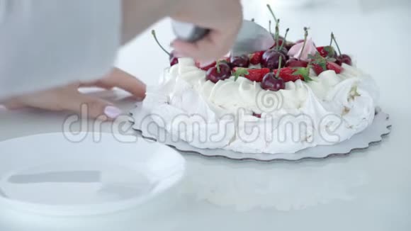 女性手切甜点带浆果的白蛋糕巴甫洛夫甜点视频的预览图