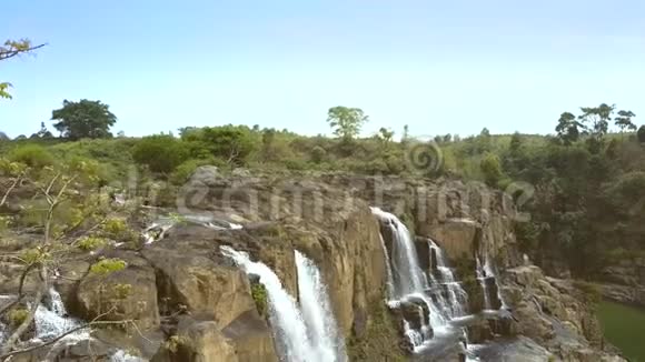 女孩拿着瑜伽姿势在岩石和瀑布之间视频的预览图