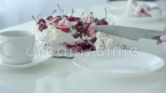 女性手切甜品放到白板上带浆果的白色蛋糕巴甫洛夫甜点视频的预览图
