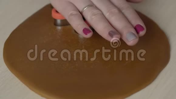 女人用饼干切割机做圣诞姜饼男人饼干圣诞节概念视频的预览图