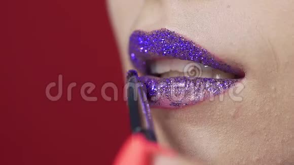 在女人嘴唇上涂上闪光剂制作明亮的晚妆嘴唇化妆化妆师工作亲密视频的预览图