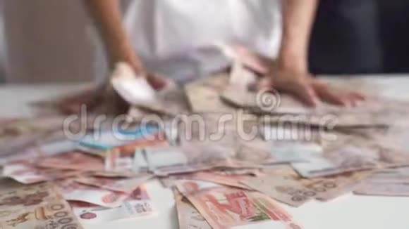 女手在一张白色的桌子上收了很多钱泰国的钞票俄罗斯的钞票视频的预览图