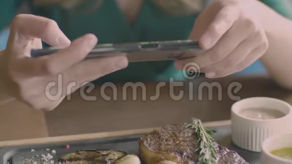 女人用手机制作牛排的食物照片视频的预览图