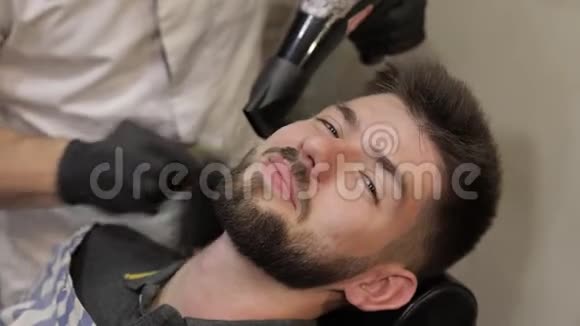 理发店刮胡子时留着黑胡子的顾客男子气概视频的预览图