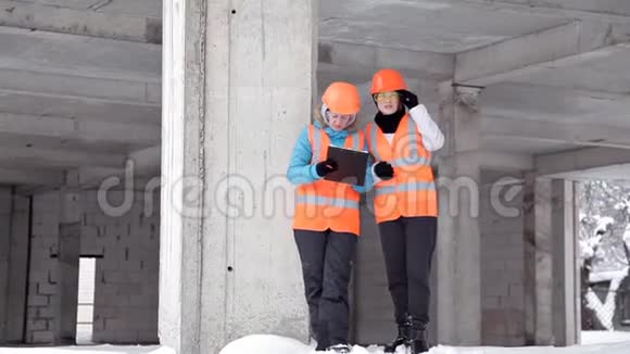 建筑工人和工程师在施工现场交谈在大楼外戴头盔的工人视频的预览图