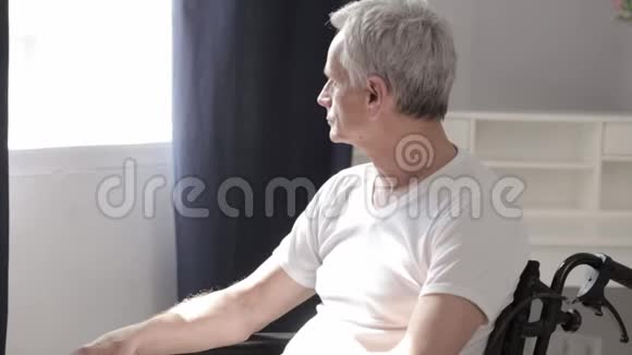医院轮椅上有白发的成年男子视频的预览图