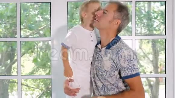 快乐的男人亲吻可爱的儿子视频的预览图