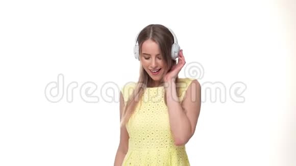 兴奋的女人戴着耳机听着音乐慢动作孤立在白色演播室的背景上视频的预览图