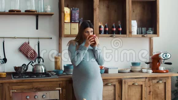厨房里喝咖啡的孕妇视频的预览图