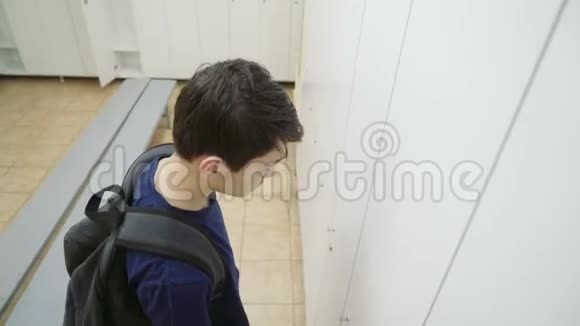 一个背着背包的年轻人打开更衣室的壁橱泳池里的衣柜4k视频的预览图