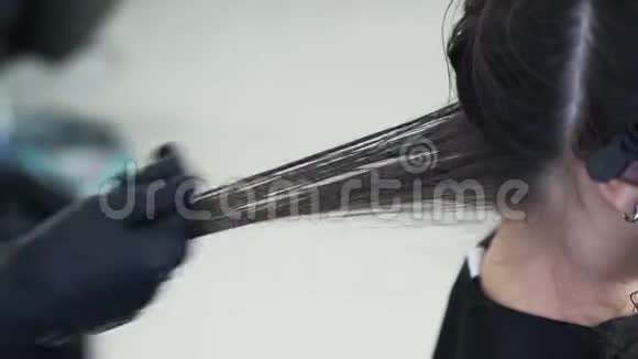 靠近理发师的手把角蛋白涂在女性头发上视频的预览图