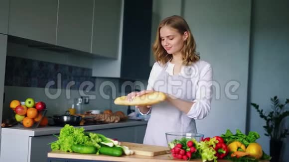 快乐女孩在厨房里打破和吃法国面包女士近桌视频的预览图