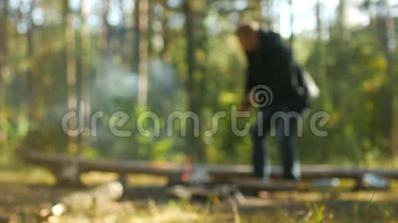 一个人在大自然的树林里生火户外娱乐模糊背景野营视频的预览图