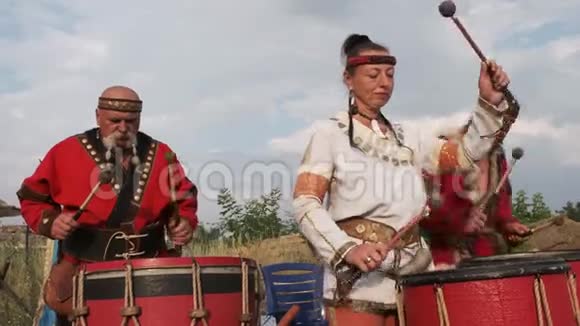 两个穿着民族服装的男人和女人在鼓声中欢快地敲打着节奏视频的预览图