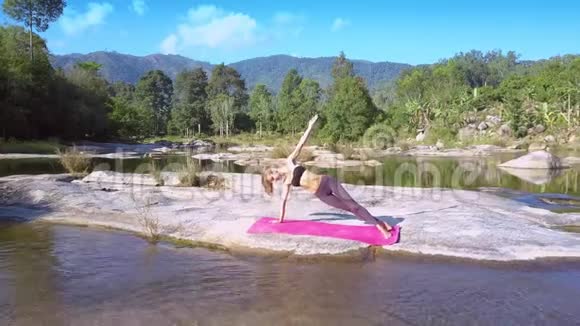 在瑜伽表演中Flycam从女孩身上移除河流急流视频的预览图