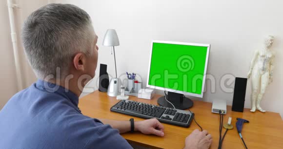 医生用绿色屏幕坐在电脑前视频的预览图