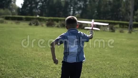 男孩在阳光明媚的天气在公园里发射一架玩具飞机心情很好慢动作视频的预览图