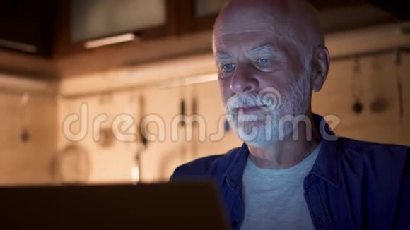 老人在使用笔记本电脑时喝杯咖啡在家庭办公室工作的自由职业者视频的预览图