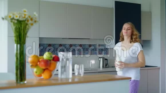 年轻女子在厨房准备麦片粥女孩放了一瓶牛奶视频的预览图