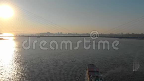 一艘大型集装箱船通过海峡驶进港口船上有一座电缆桥视频的预览图