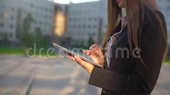 女商人用数码平板电脑关门走在阳光明媚的早晨城市动作缓慢专业人士视频的预览图