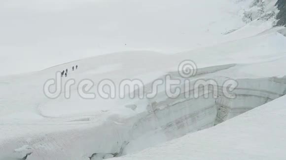在裂缝附近的冰川上行走的游客观到门苏冰川贝鲁卡山区阿尔泰俄罗斯视频的预览图