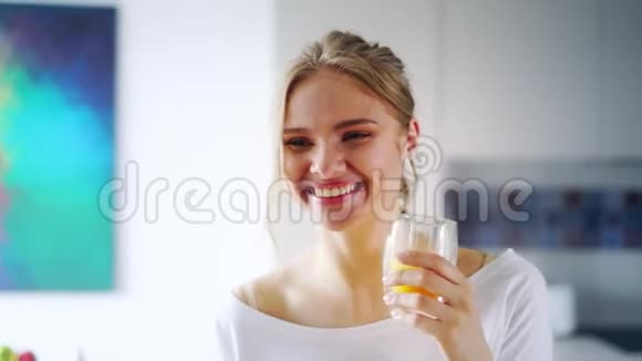 美丽的女孩喝着新鲜的橙汁从玻璃亲近幸福的女人视频的预览图