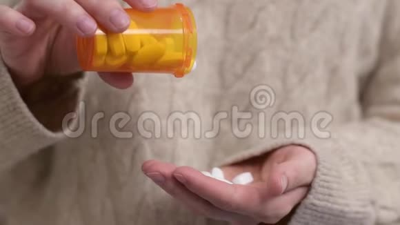 女人吃维他命女人把药丸倒进手掌视频的预览图