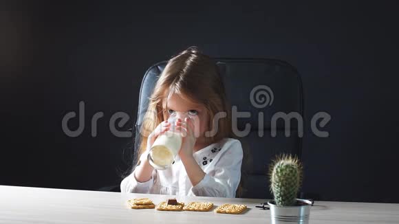 快乐美丽的小女孩吃点带牛奶和饼干的零食视频的预览图