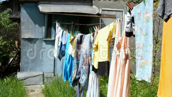 洗的便服和不同的亚麻布挂在后院的晾衣绳上视频的预览图