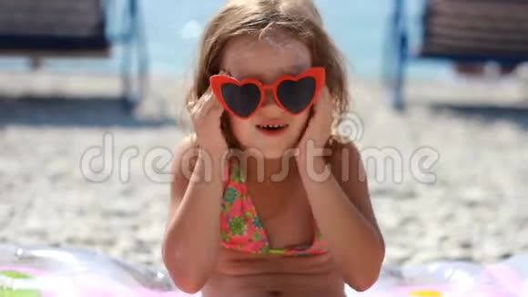 儿童涂抹太阳霜的节日和身体晒伤防晒霜防晒霜戴太阳镜可爱的女婴视频的预览图