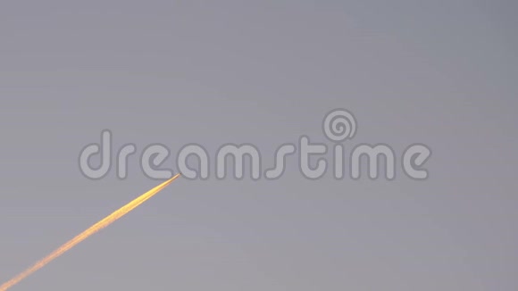 客机在天空中飞得很高在夕阳中留下了烟雾的痕迹视频的预览图