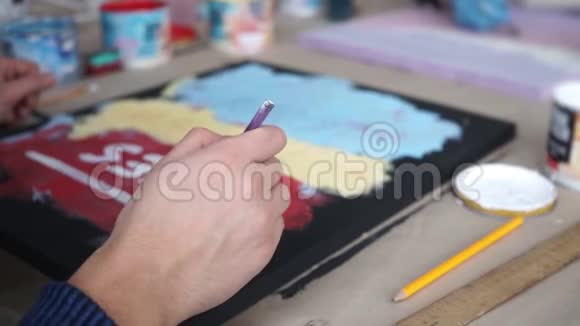 男手用毛笔画字母彩色背景艺术工作室合作同事视频的预览图