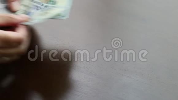 女人在桌上为男人数一百元钞票视频的预览图
