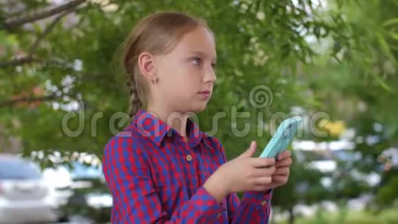 绿色公园里金发少女用手机挥舞着昆虫视频的预览图