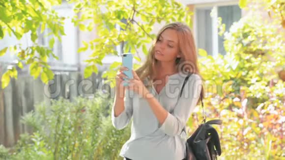 一位长发美女在他的智能手机户外稳定镜头上自拍视频的预览图