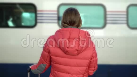 年轻女子站在车站站台等车视频的预览图