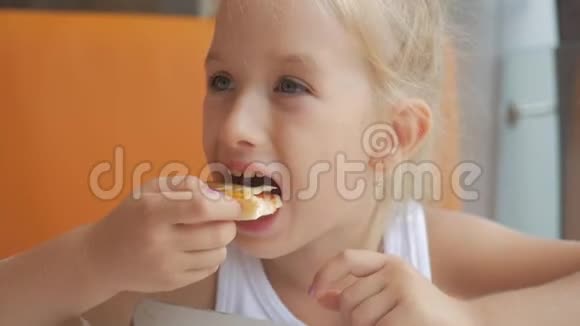 小女孩在室内快餐店吃披萨最后一块有趣的小女孩吃比萨饼微笑着视频的预览图