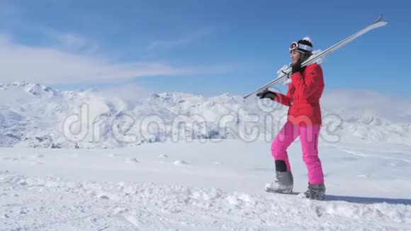 在运动中一个女滑雪者在斜坡山上滑雪在她的肩膀上滑雪视频的预览图