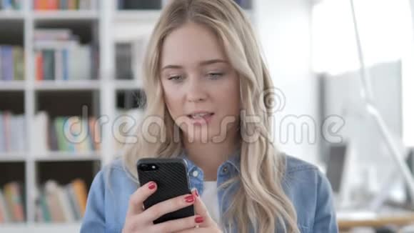 年轻女性使用电话打字信息视频的预览图