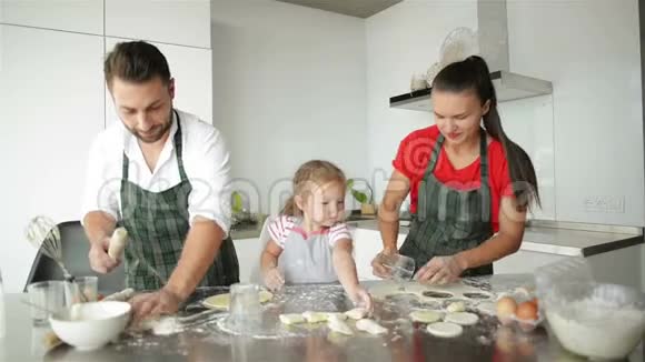 可爱的父母正在教他们的女儿如何做披萨他们在一起心情很好视频的预览图