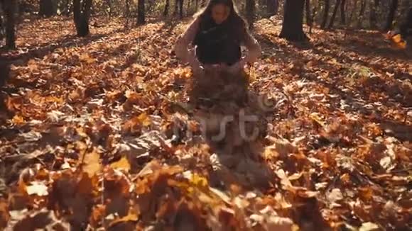 少女正在森林里玩干燥的树叶在空中呕吐视频的预览图
