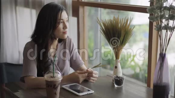 年轻女子在咖啡馆里休息思考视频的预览图