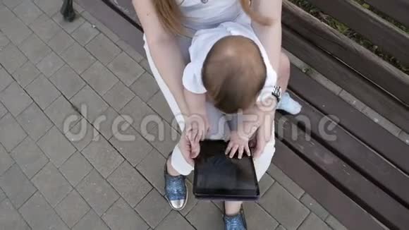 幸福的家庭带着数码平板电脑在公园休息的母女视频的预览图