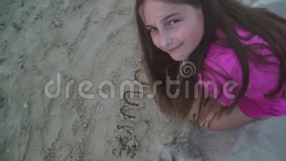 美丽的少女在河边的沙滩上画画视频的预览图
