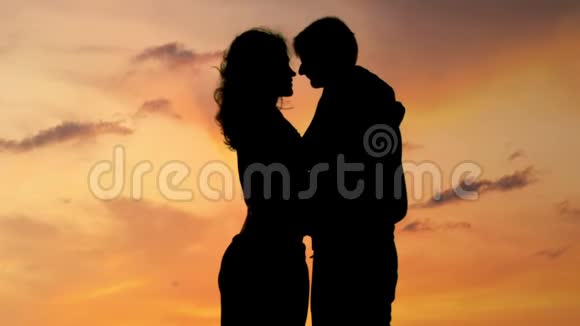 美丽浪漫的情侣享受着令人惊叹的日落亲吻和拥抱特写视频的预览图